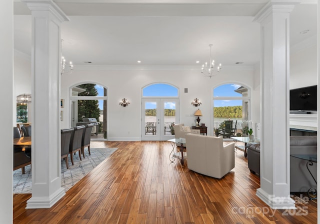 102 Stone Point Ct, Mooresville, NC 28117 - living room featuring crown molding, ornate columns, a chandelier, and hardwood / wood-style flooring