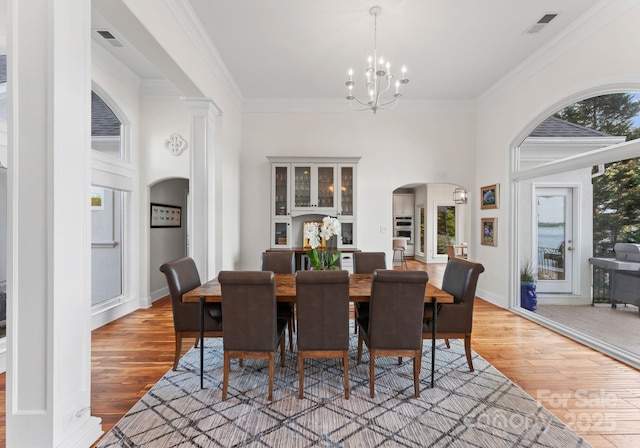 102 Stone Point Ct, Mooresville, NC 28117 - dining space featuring a wealth of natural light, arched walkways, light wood-type flooring, visible vents, and a notable chandelier