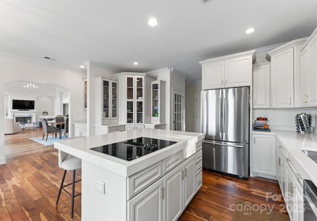 102 Stone Point Ct, Mooresville, NC 28117 - kitchen featuring white cabinets, arched walkways, light countertops, freestanding refrigerator, and black electric stovetop
