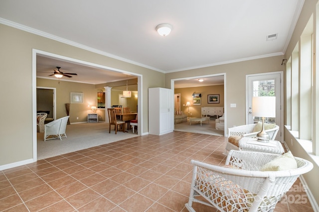 living room with visible vents, ornamental molding, light tile patterned floors, baseboards, and ceiling fan