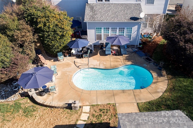 outdoor pool with a patio and outdoor dining space