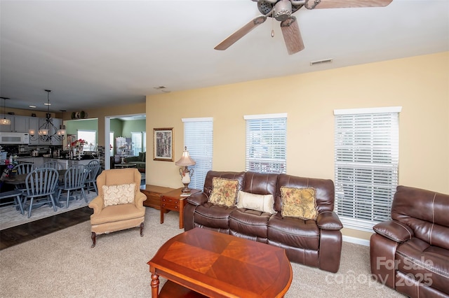 carpeted living room featuring visible vents and a ceiling fan