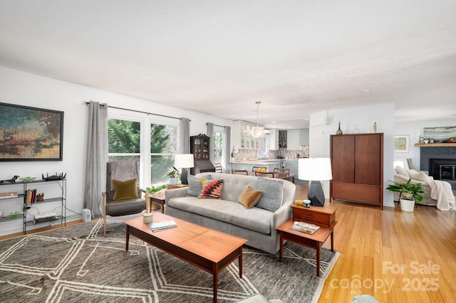 36 Brookcliff Dr, Asheville, NC 28804 - living room featuring a notable chandelier, a fireplace, and light wood finished floors