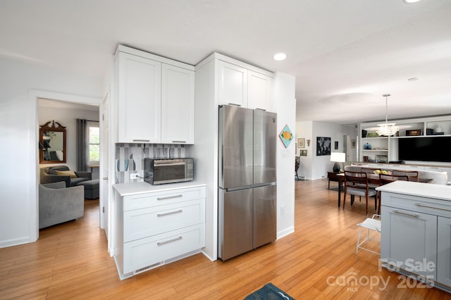36 Brookcliff Dr, Asheville, NC 28804 - kitchen with light countertops, a notable chandelier, light wood-style floors, and freestanding refrigerator