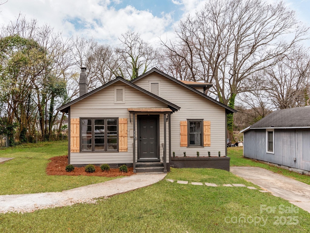 507 N Oakland St, Gastonia, NC 28052 - bungalow-style home with a front yard and a chimney