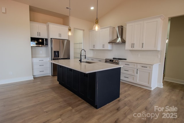 1370 Coppergate Dr, Salisbury, NC 28147 - kitchen with wall chimney exhaust hood, appliances with stainless steel finishes, white cabinets, light countertops, and an island with sink