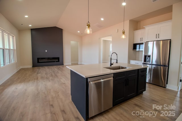 1370 Coppergate Dr, Salisbury, NC 28147 - kitchen featuring stainless steel appliances, lofted ceiling, white cabinetry, light countertops, and light wood-style floors