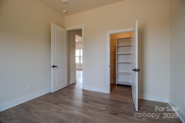 1370 Coppergate Dr, Salisbury, NC 28147 - unfurnished bedroom with a spacious closet, wood finished floors, and a closet
