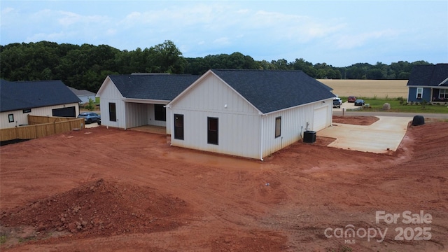 1370 Coppergate Dr, Salisbury, NC 28147 - rear view of house with a shingled roof, a detached garage, and board and batten siding