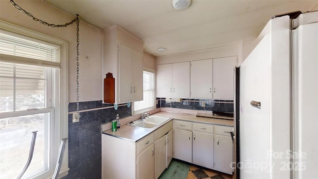 11 Season Ln, Asheville, NC 28805 - kitchen with freestanding refrigerator, light countertops, white cabinets, tile walls, and decorative backsplash