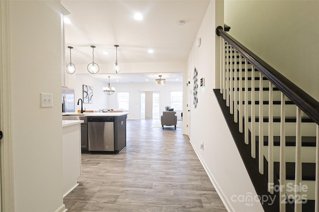 13024 Suncreek Ter, Charlotte, NC 28214 - interior space featuring recessed lighting, light wood-type flooring, baseboards, appliances with stainless steel finishes, and a notable chandelier