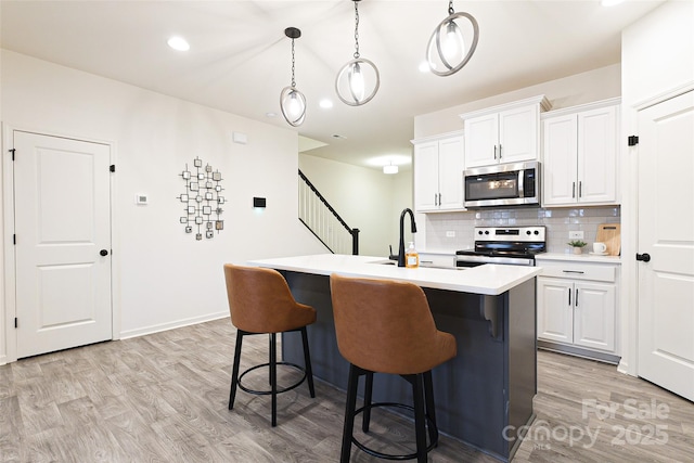 13024 Suncreek Ter, Charlotte, NC 28214 - kitchen featuring stainless steel appliances, light countertops, a sink, light wood-style floors, and decorative backsplash