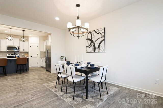 13024 Suncreek Ter, Charlotte, NC 28214 - dining space with a chandelier, light wood finished floors, baseboards, and recessed lighting