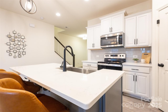 13024 Suncreek Ter, Charlotte, NC 28214 - kitchen featuring stainless steel appliances, a breakfast bar, a sink, tasteful backsplash, and white cabinetry