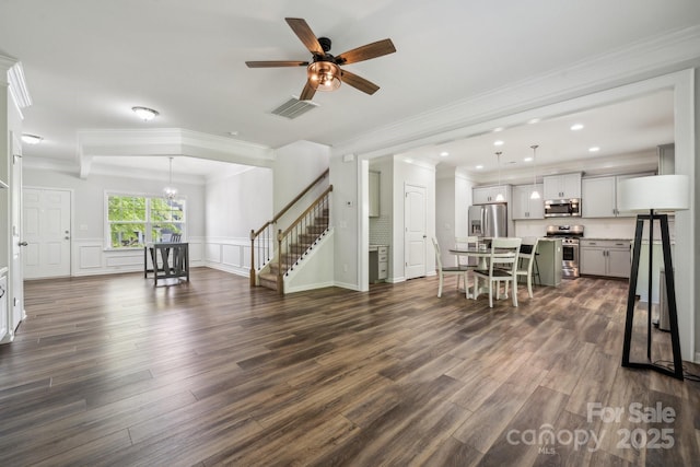 117 Cramerton Mills Parkway, Cramerton, NC 28032 - living room with crown molding, ceiling fan with notable chandelier, dark wood-style floors, and stairs