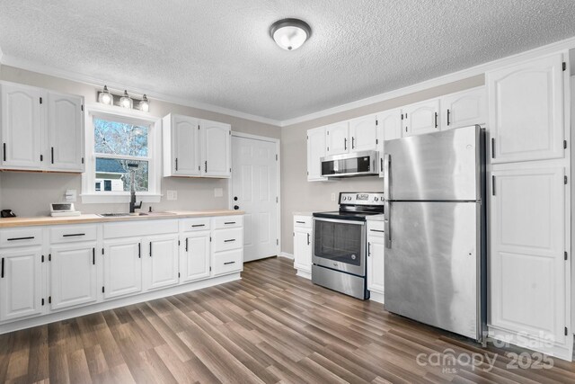kitchen featuring stainless steel appliances, dark wood finished floors, and white cabinets