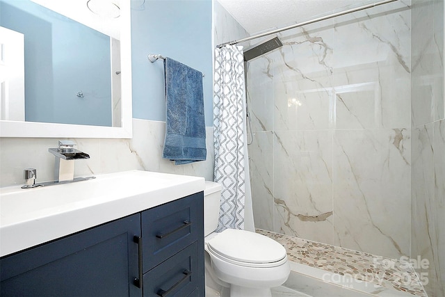 full bathroom featuring tile walls, toilet, a stall shower, and vanity