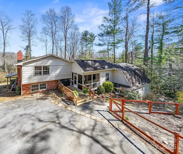 203 Davis Mountain Rd, Laurel Park, NC 28739 - view of front facade with a sunroom, a chimney, a patio, brick siding, and asphalt driveway