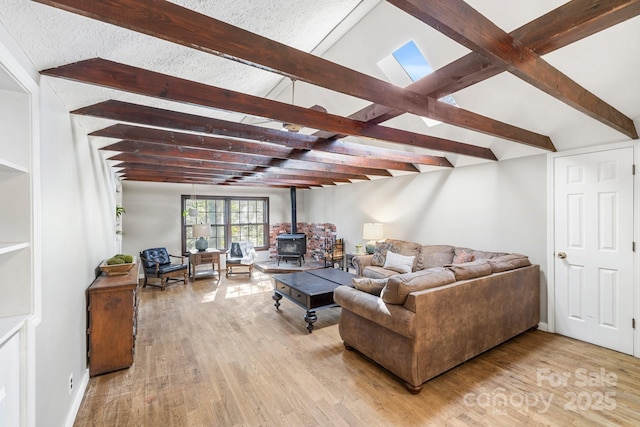 203 Davis Mountain Rd, Laurel Park, NC 28739 - living area with a wood stove, light wood-type flooring, and beam ceiling
