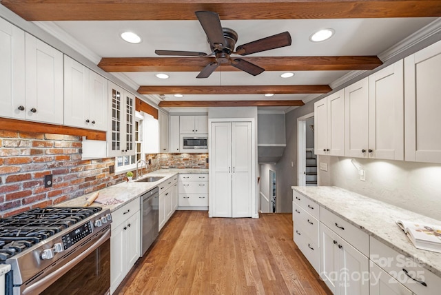 203 Davis Mountain Rd, Laurel Park, NC 28739 - kitchen featuring stainless steel appliances, white cabinetry, light wood-style floors, decorative backsplash, and beamed ceiling