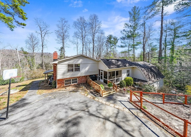 203 Davis Mountain Rd, Laurel Park, NC 28739 - view of front of property featuring a sunroom, a chimney, asphalt driveway, brick siding, and a patio