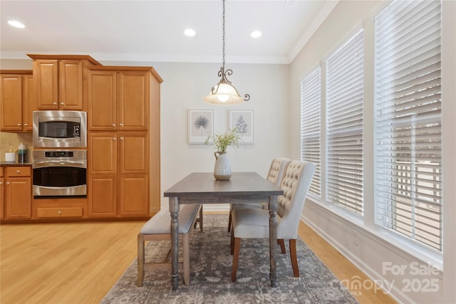 dining room with crown molding, light wood-style flooring, and recessed lighting