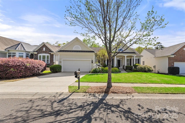 view of front of property with driveway, an attached garage, metal roof, a front lawn, and a standing seam roof