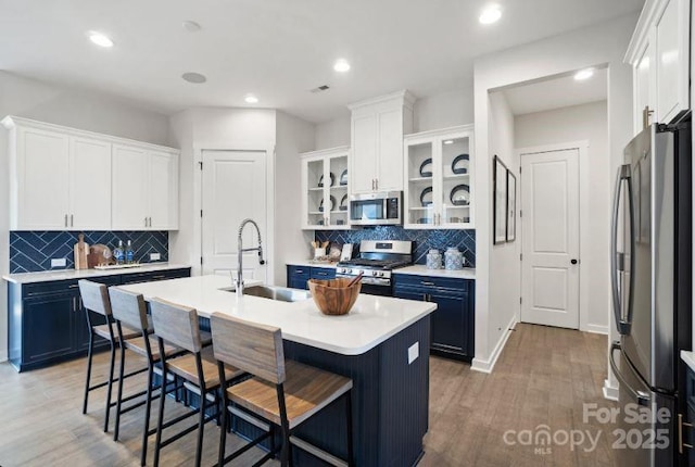 324 Basil Dr, Indian Trail, NC 28079 - kitchen with appliances with stainless steel finishes, a kitchen breakfast bar, decorative backsplash, a kitchen island with sink, and recessed lighting