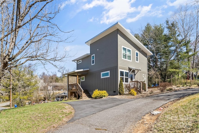 view of property exterior with crawl space, a lawn, and driveway