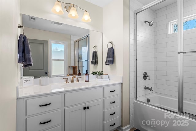 full bathroom with vanity, visible vents, combined bath / shower with glass door, and a healthy amount of sunlight