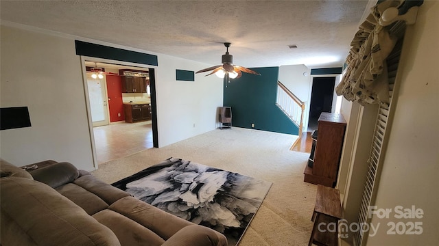 living room with light carpet, visible vents, a textured ceiling, and a ceiling fan