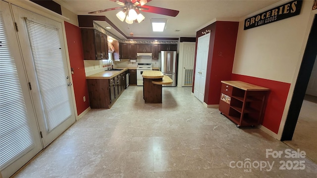 kitchen featuring white electric range oven, freestanding refrigerator, a sink, light countertops, and under cabinet range hood