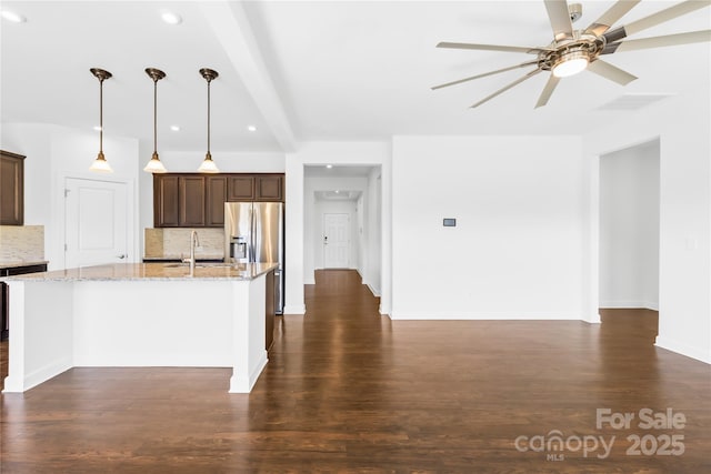 kitchen featuring light stone countertops, stainless steel fridge with ice dispenser, ceiling fan, dark wood-type flooring, and tasteful backsplash