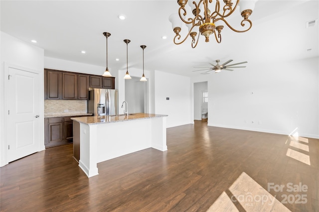 kitchen with a sink, decorative light fixtures, stainless steel fridge with ice dispenser, decorative backsplash, and dark wood-style flooring