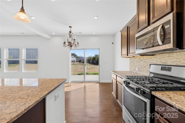 kitchen with pendant lighting, tasteful backsplash, stainless steel appliances, a chandelier, and dark wood-style flooring