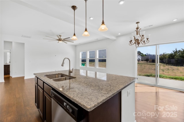 kitchen featuring light stone countertops, visible vents, dark wood finished floors, a sink, and stainless steel dishwasher