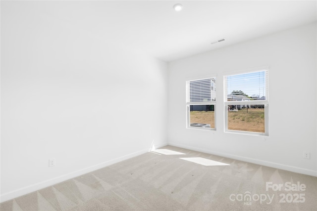 carpeted empty room with baseboards and visible vents