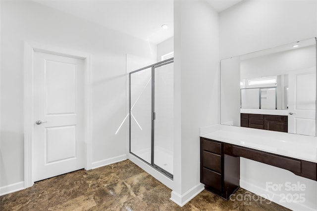bathroom featuring a shower stall, vanity, and baseboards