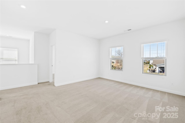 unfurnished room with visible vents, baseboards, and carpet