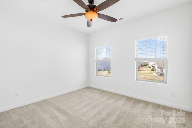 unfurnished room with a ceiling fan, visible vents, carpet, and baseboards