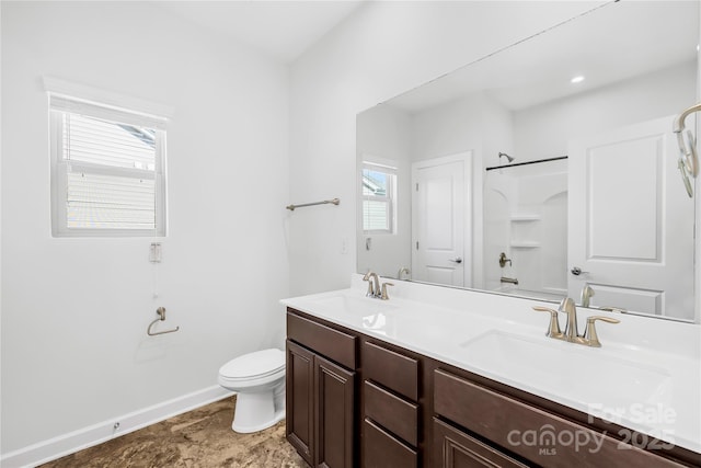 full bath featuring walk in shower, toilet, double vanity, and a sink