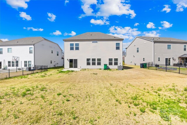 back of property featuring a residential view, a lawn, and fence