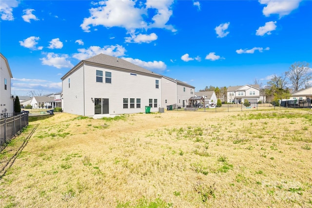 back of property with a residential view and fence