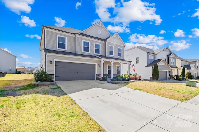 traditional-style home with a residential view, a front yard, driveway, stone siding, and an attached garage