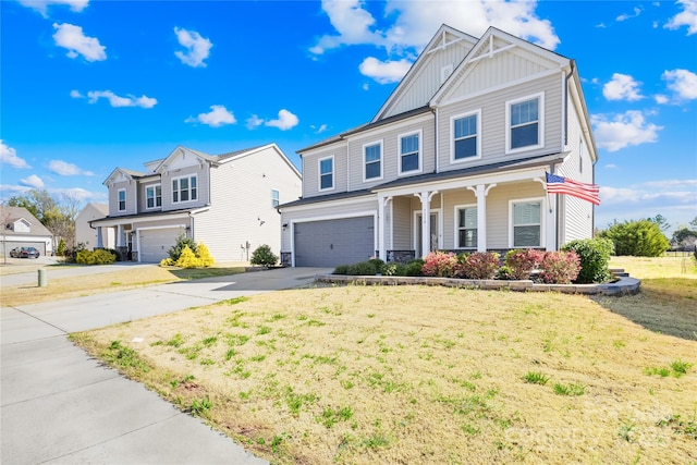 view of front of property featuring board and batten siding, a porch, a front yard, driveway, and an attached garage