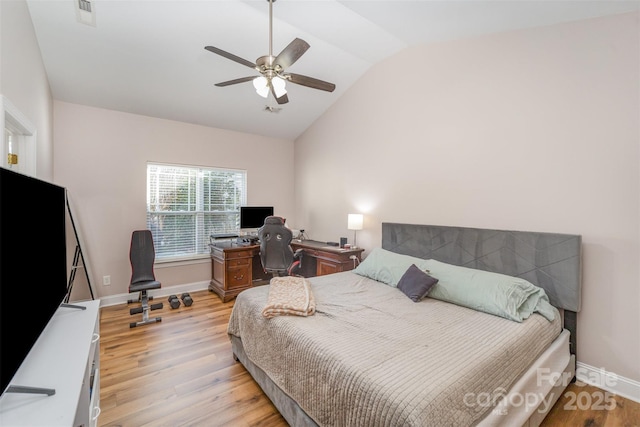 bedroom with a ceiling fan, light wood-type flooring, baseboards, and vaulted ceiling