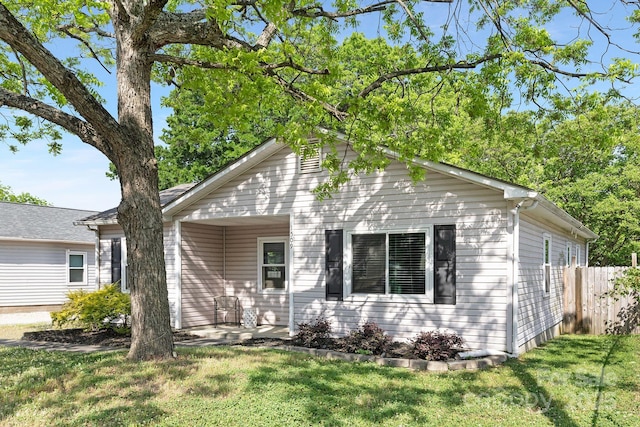 view of front of property featuring a front lawn and fence