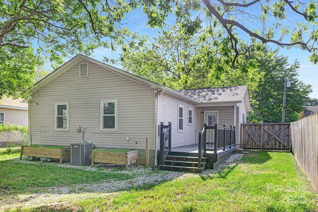 rear view of property featuring a lawn, a deck, a gate, central AC, and fence