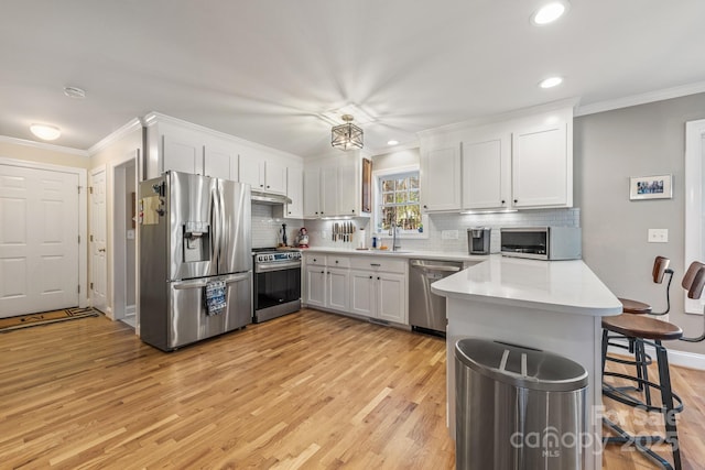 7025 Ridgeway Rd, Stanley, NC 28164 - kitchen featuring appliances with stainless steel finishes, light wood finished floors, ornamental molding, light countertops, and white cabinets