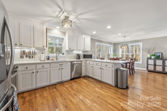 7025 Ridgeway Rd, Stanley, NC 28164 - kitchen featuring stainless steel appliances, light wood-style floors, a peninsula, recessed lighting, and tasteful backsplash